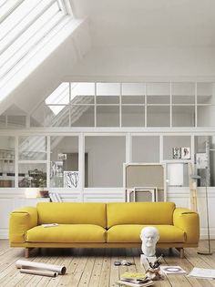 a living room with a yellow couch and white walls in the background is an image of a woman standing on her knees