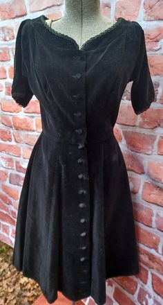 "A classic black velvet dress with a circle skirt and detailed lace on neckline and sleeves with 17 buttons up the front.  Made by Arnold's Wellesley a Lansville original.  This is the perfect funeral dressor any occasion calling for a Vintage classic.  Bust 32\"  A-B. Waist 26\"  hip 34\"  shoulder to waist 15\"  waist to hem 24\"  The fabric is non stretch." Classic Vintage Dress With Buttons For Formal Occasions, Classic Black Dress For Vintage Events, 70s Black Dress, Consumer Board, Vintage Christmas Dress, Cotton Long Dress, Vintage Black Dress, Black Velvet Dress, Dinner Dress