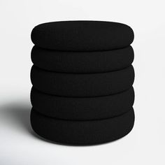 five black round cushions stacked on top of each other in front of a white background