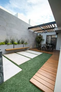 an outdoor patio with grass and wooden benches