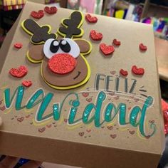 someone holding up a cardboard box with a reindeer face on it and hearts around the eyes