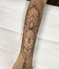 a woman's foot with a tattoo design on the side of her leg,