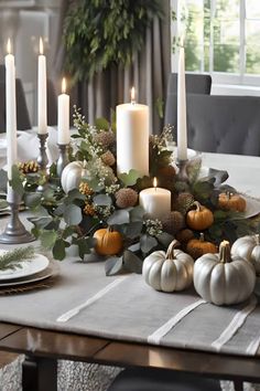 a dining room table decorated with candles and pumpkins