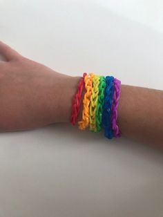 a person's arm with several bracelets on it, all in different colors