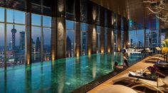 an advertisement for the four seasons shanghai pudong hotel in china, with a pool and cityscape