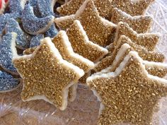 several cookies with sprinkles are on a clear plastic tray and one is cut in half to look like stars