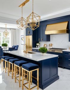 a kitchen with blue cabinets, gold accents and white marble countertops is pictured in this image