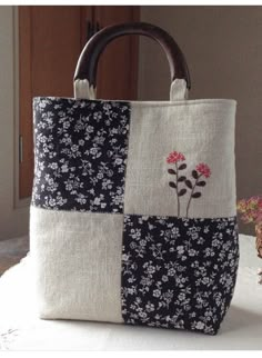 a handbag sitting on top of a table next to a basket filled with flowers