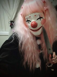 a creepy clown with pink hair holding a knife