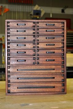 a wooden box that has many drawers on it