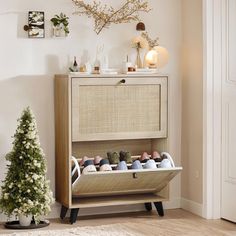 a wooden shoe rack with several pairs of shoes in it next to a christmas tree