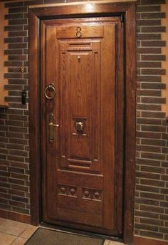 a wooden door in front of a brick wall