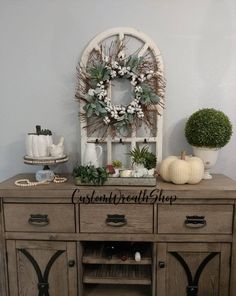 an old dresser with wreaths and other decorations on top