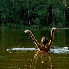 a woman swimming in the middle of a lake