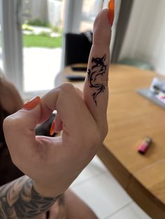 a person with a tattoo on their hand holding up the finger and pointing at something