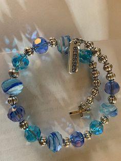 Sea blue beaded wrap bracelet has a cross charm and a blessed charm Handmade Bracelets Tutorial, White Pearl Bracelet, Memorial Bracelet, Wrist Jewelry, Gems Bracelet, Beaded Jewelry Tutorials, Beads Bracelet Design, Jewelry Accessories Ideas, Beaded Wrap Bracelets