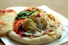 two pizzas with different toppings sitting on top of each other in napkins