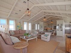 a living room filled with furniture next to a kitchen