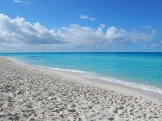 a beach with blue water and white sand