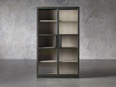 an empty bookcase sitting on top of a cement floor next to a concrete wall