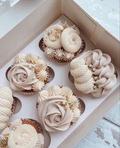 six cupcakes with white frosting in a box