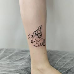 a small tattoo on the leg of a woman's foot with an image of a dog