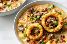 two bowls filled with soup and onion rings