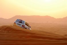 a white van driving through the desert at sunset