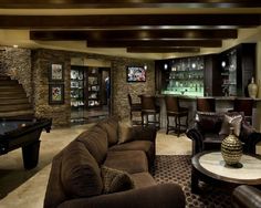 a living room filled with lots of furniture and a pool table in front of a bar