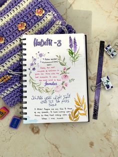 a crocheted notebook with flowers and writing on it next to a pair of scissors