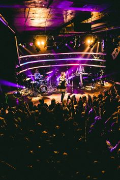 a group of people that are standing in the middle of a stage with lights on