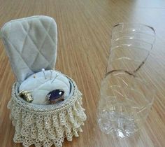 a small white box sitting on top of a wooden table next to a glass vase