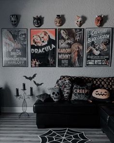 a living room filled with black furniture and lots of posters on the wall above it