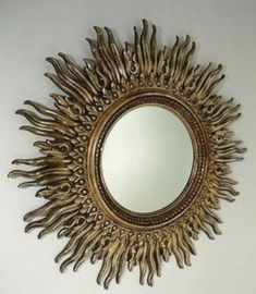 a mirror that is on the wall in front of a white wall with an artistic design