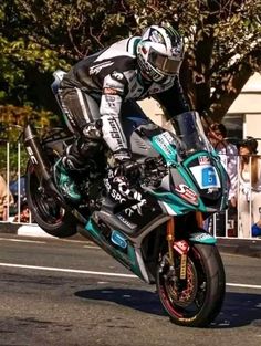 a man riding on the back of a motorcycle down a street