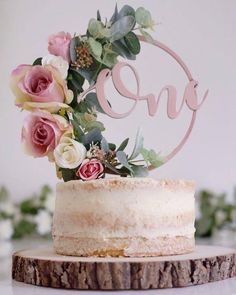 there is a cake with flowers on it and the word ome spelled in pink