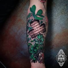 a woman's arm with shamrocks and heart shaped leaves on the inside of it