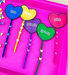 four heart shaped lollipop sticks with the word purple written on them in different colors