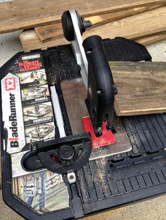 a table saw is sitting on top of some wood planks and other construction materials