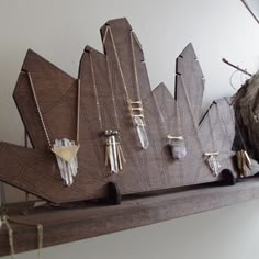 a shelf with several pieces of jewelry hanging from it's sides and on top