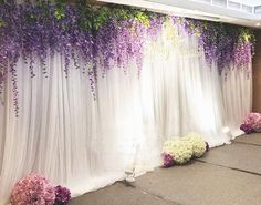 purple and white flowers decorate the backdrop for a wedding