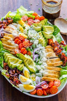 a large salad with avocado, tomatoes, lettuce and other vegetables