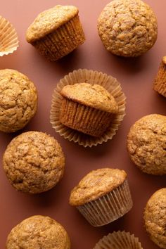 several muffins are arranged on a brown surface