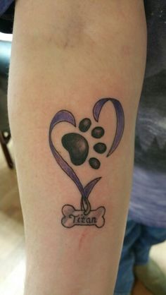 a tattoo on the leg of a woman with a dog's paw and heart