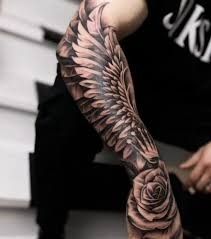 a man with a rose and wings tattoo on his arm