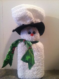 a stuffed snowman wearing a black hat and green scarf