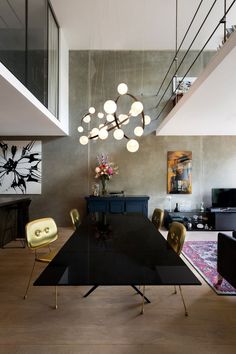 a dining room table with chairs and a chandelier hanging from it's ceiling