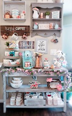 a table with some plates and cups on it in front of shelves filled with items