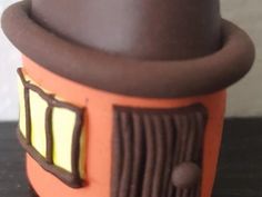 an orange and brown toy with a top hat on it's head sitting on a table