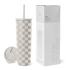 a white and grey checkered cup next to a cardboard box with a straw in it